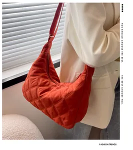 Detail der leuchtend orangen Hobo-Tasche mit Rautensteppung und verstellbarem Schultergurt