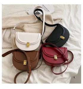 Saddle crossbody bags in white black brown and burgundy with gold buckles on fabric