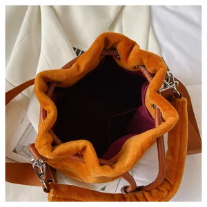 Close-up of orange plush bucket bag showing wine red lining and interior storage space