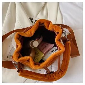 Detail view of large capacity plush bucket bag with wide strap and soft hand-feel texture