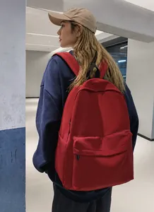 Dettaglio dello zaino rosso in tela con tasca frontale a zip e scomparti laterali capienti