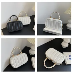 Détail du sac à main ovale matelassé avec poignée tressée et fermoir en métal doré chic