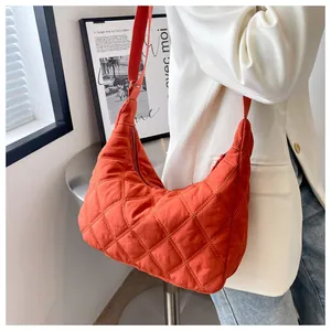 Detail der orangefarbenen Stepptasche mit verstellbarem Riemen und Nylon-Textur
