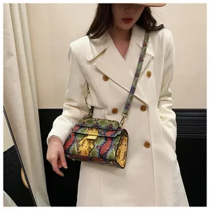 Detail of colorful snakeskin texture crossbody bag with gold metallic clasp and strap