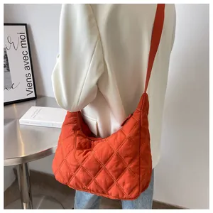 Orangefarbene Stepptasche im Hobo-Stil kombiniert mit einem weißen Blazer