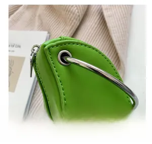 Close-up of bright green snake pattern bag with silver metal ring handle and zipper