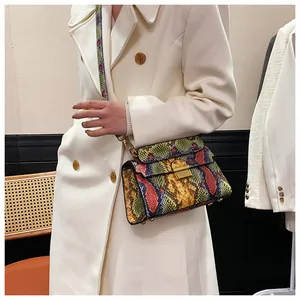 Detailed view of rainbow python pattern shoulder bag on a white coat model