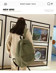Riferimento taglia zaino verde oliva su modella di 165cm in una galleria d'arte