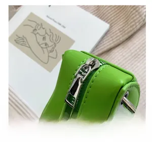 Detailed macro view of the smooth silver zipper on a vibrant green snakeskin textured bag