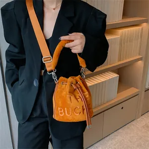 Fashion orange suede bucket bag with THE BUCKET embossing and wide shoulder strap