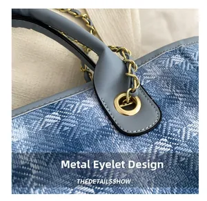 Macro view of woven blue fabric detail with leather trim and gold chain hardware