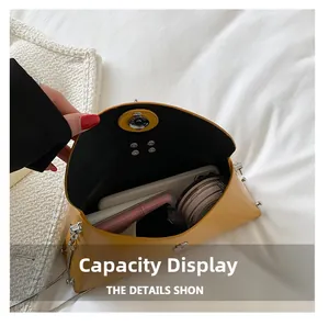 Macro view showing internal capacity of yellow leather chain bag with silver magnetic snap