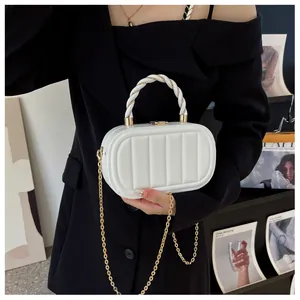 Vue détaillée du sac pochette blanc matelassé avec anse tressée dorée et chaîne