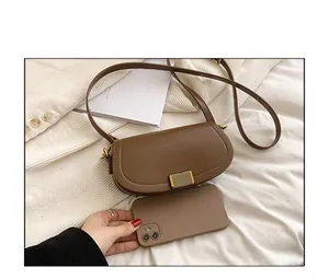 Detailed comparison showing brown saddle bag size relative to a smartphone in daily use