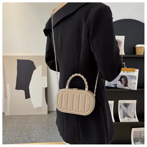 Détail du sac boîte ovale plissé kaki avec poignée tressée et chaîne dorée