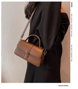 Detail of a dark brown vintage leather handbag with gold hardware and strap