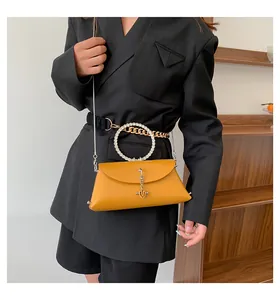 Détail du sac jelly jaune gingembre avec poignée ronde en strass et bandoulière chaîne