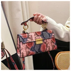 Detail of pink and black snakeskin texture with gold ring handle and metal clasp