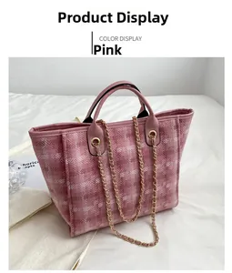Detailed view of pink fabric tote bag with leather handles and gold metal chain straps