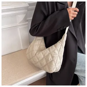 Detailansicht der beigen gesteppten Halbmond-Schultertasche mit weichem Rautenmuster