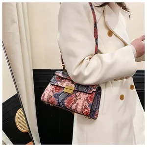 Detail of colorful snakeskin texture handbag with gold square clasp worn by model