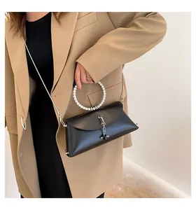 Détail d'un sac jelly noir avec poignée ronde incrustée de cristaux et bandoulière chaîne