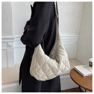 Detailansicht der beigen gesteppten Hobo-Tasche mit verstellbarem Riemen am Model