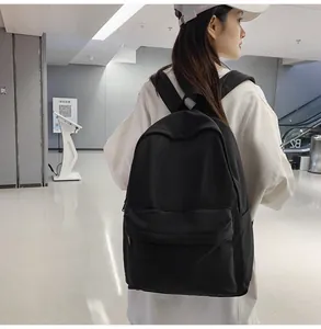 Rear view of a black high-density nylon backpack with spacious compartments on model