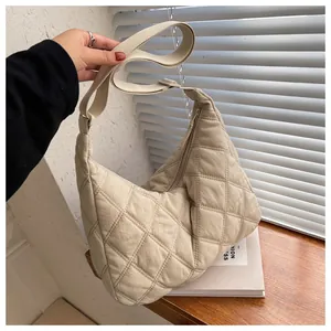 Detail der beigen gesteppten Crossbody-Halbmondtasche mit Reißverschluss und Gurt