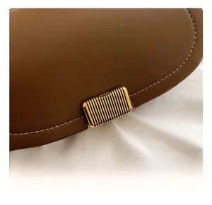 Detailed macro view of the brown leather texture and vertical striped gold metal lock