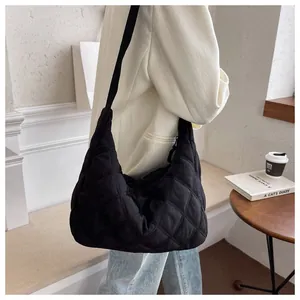Detail der schwarzen gesteppten Nylon-Halbmondtasche am Modell im Café gezeigt