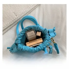Top view of mini light blue drawstring bucket bag showing interior space for makeup