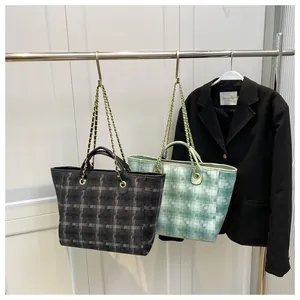 Detail of large tote bags in gray plaid and green quilted fabric with gold chain straps