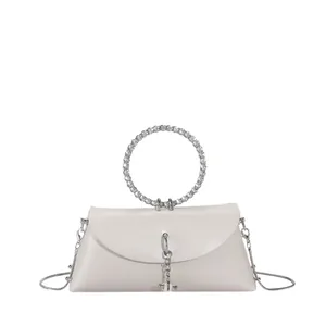 Détail du sac élégant avec poignée circulaire ornée de strass brillants et bandoulière