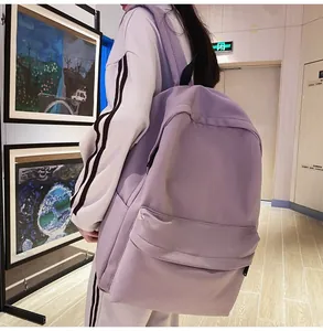 Side view of a large capacity lavender purple student backpack with side pocket on a model