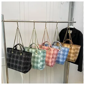 Detail of plaid tote bags in five colors with metal chain straps on a retail stand