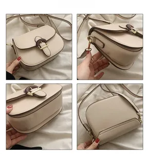 Detail view of cream saddle bag with wood-texture buckle and gold-tone metal hardware