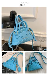 Macro shot of sky blue mini crossbody bag featuring drawstring closure and gold lettering