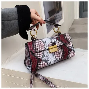 Detailed close-up of snakeskin pattern handbag with elegant gold square metal buckle clasp