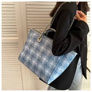 Detailed shot of large denim tote bag featuring white geometric diamond jacquard patterns