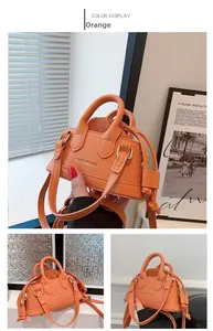 Detail of orange mini handbag with drawstring liner and fashion-engraved text
