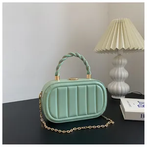 Détail d'un sac à main en cuir matelassé vert menthe avec chaîne dorée et poignée spirale