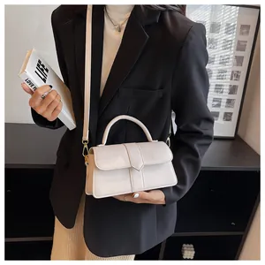 Detail of minimalist cream PU leather handbag with top handle and vertical seam design