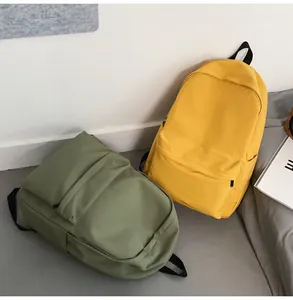 Detail view of large capacity nylon school backpacks in olive green and bright yellow colors