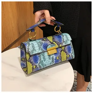 Detail of multi-color snakeskin pattern flap bag with a golden metal lock closure