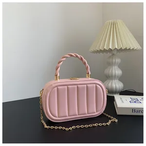 Sac boîte rose en similicuir avec rayures matelassées verticales et poignée tressée