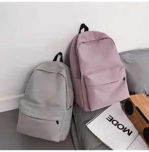 Detail of minimalist waterproof nylon backpacks in light grey and pale lavender colors