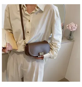 Detail of dark brown saddle bag with gold metal buckle shown in a lifestyle setting