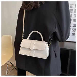 Chic cream leather rectangular crossbody bag shown on a model in a minimalist setting