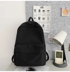 Minimalist black canvas backpack for students featuring a large main pocket and side slots